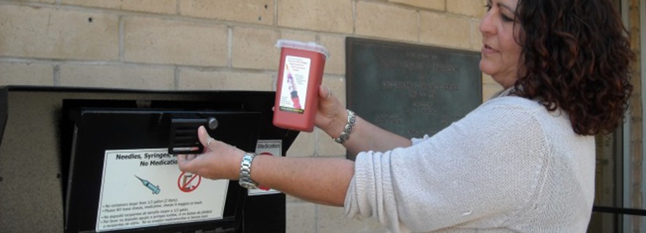 Woman disposing of sharps container at County kiosk