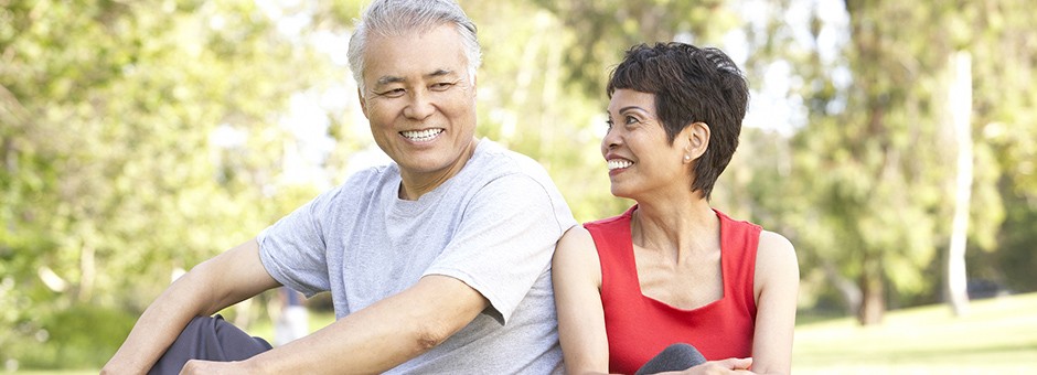 Two seniors sitting outside in a park