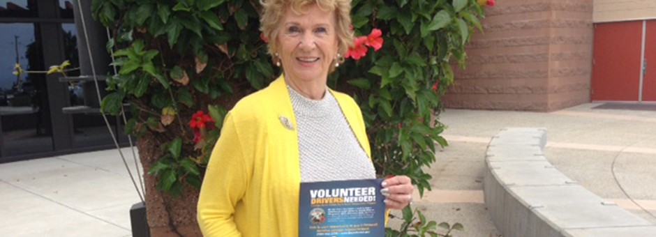 Woman holding "volunteer drivers needed" flyer