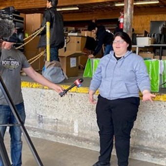 Computer recipient Aurora being interviewed by a local news station about the computer giveaway event